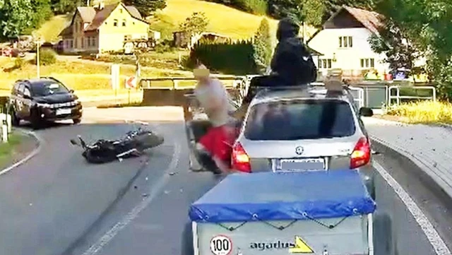 El choque impactante de una motociclista con un aterrizaje de película sobre un auto